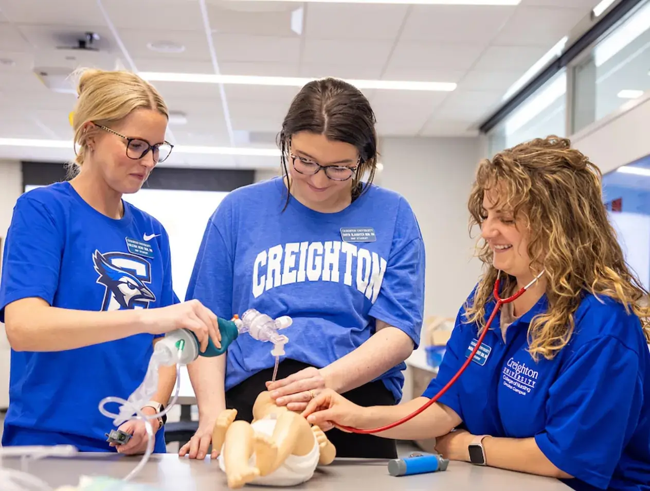 Three nursing students practicing intubation on a manikin