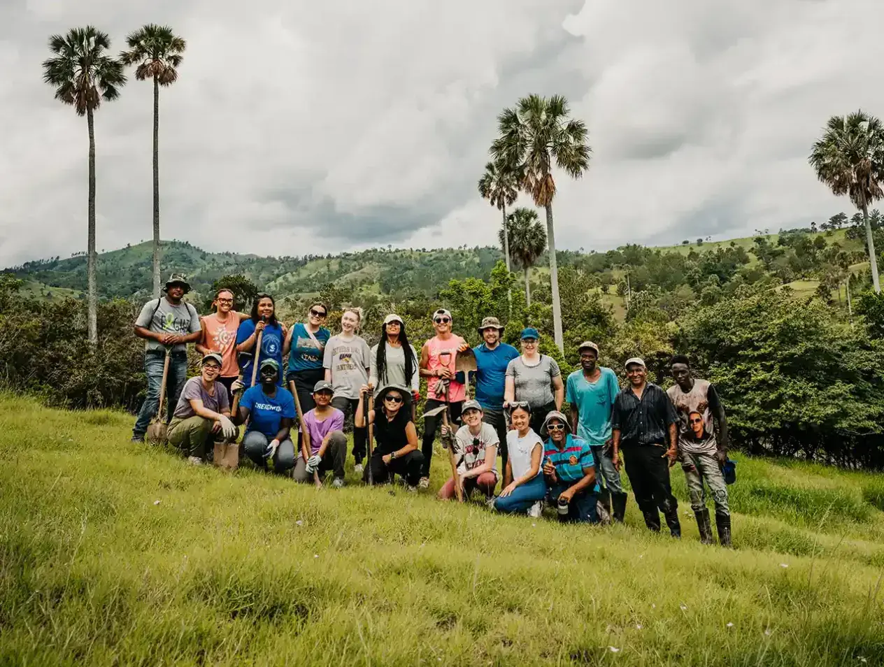 Students gather in Dominican Republic amidst lush green countryside.