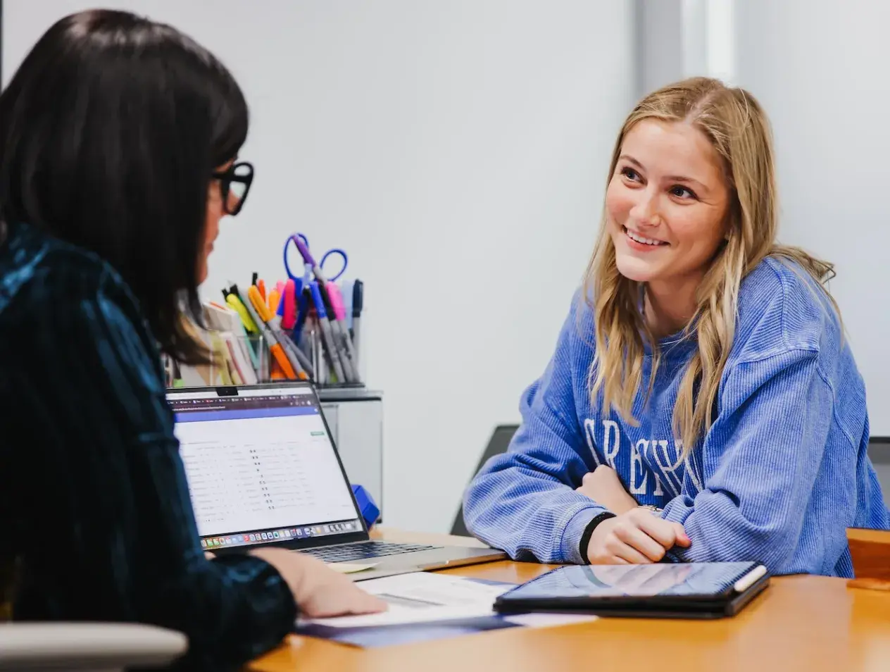 Student with staff member at a desk.