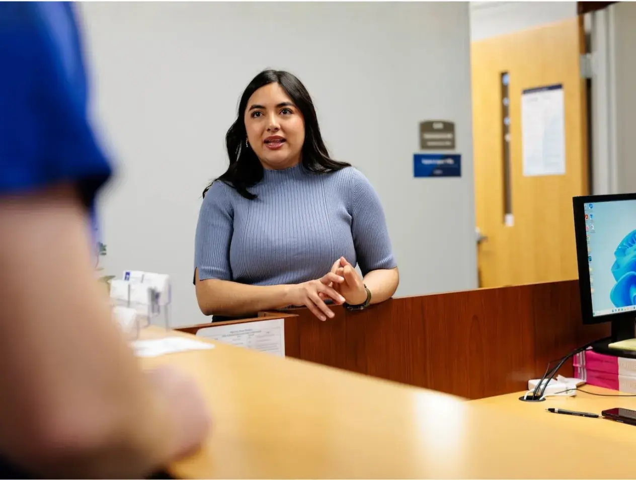 Advisor talking to a student at a desk.