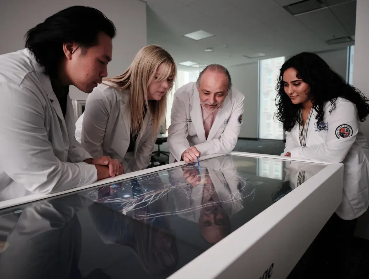 Professor and students looking at Anatomage Table. 