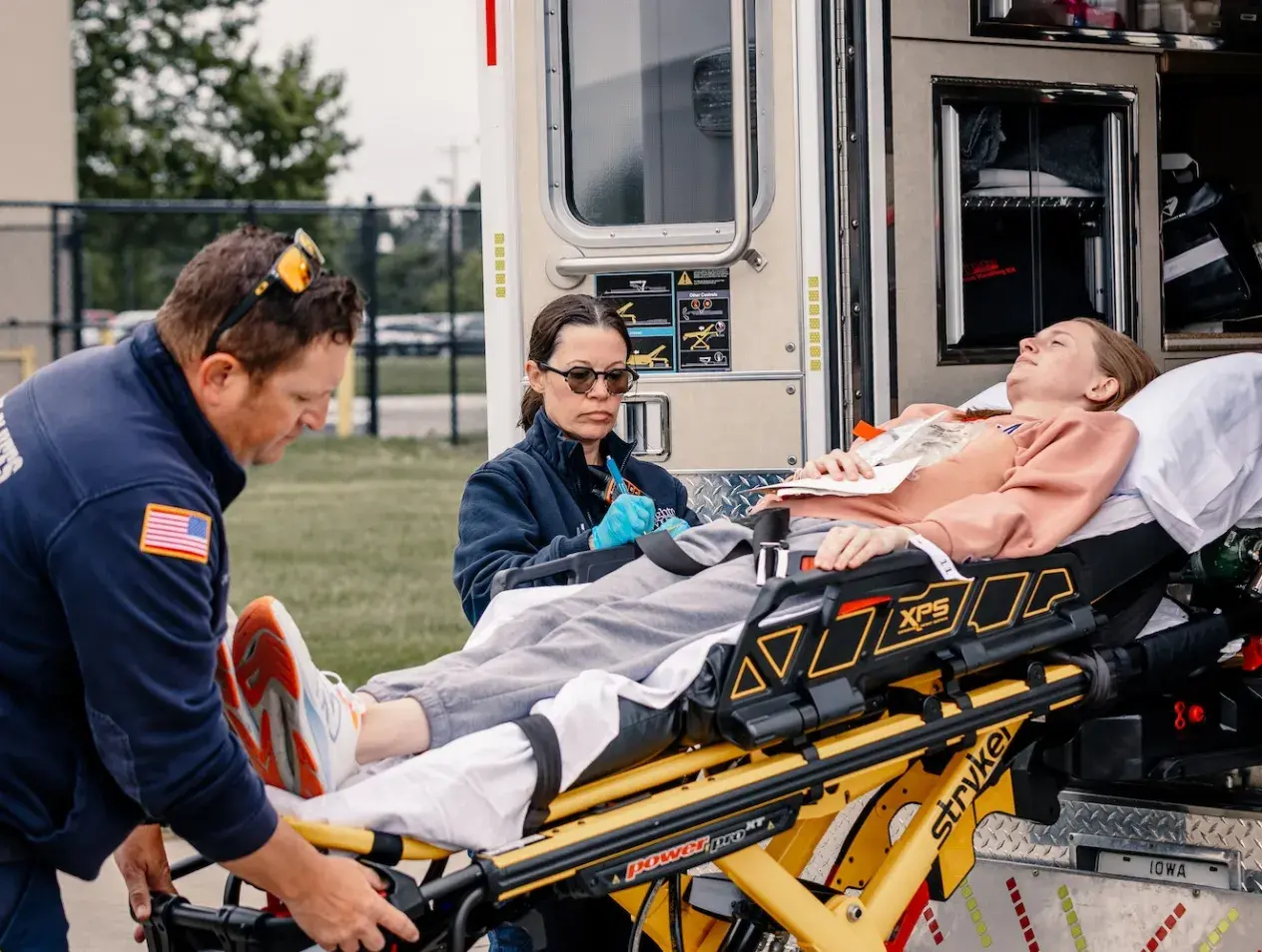 Paramedicine students loading patient into ambulance in simulation experience.