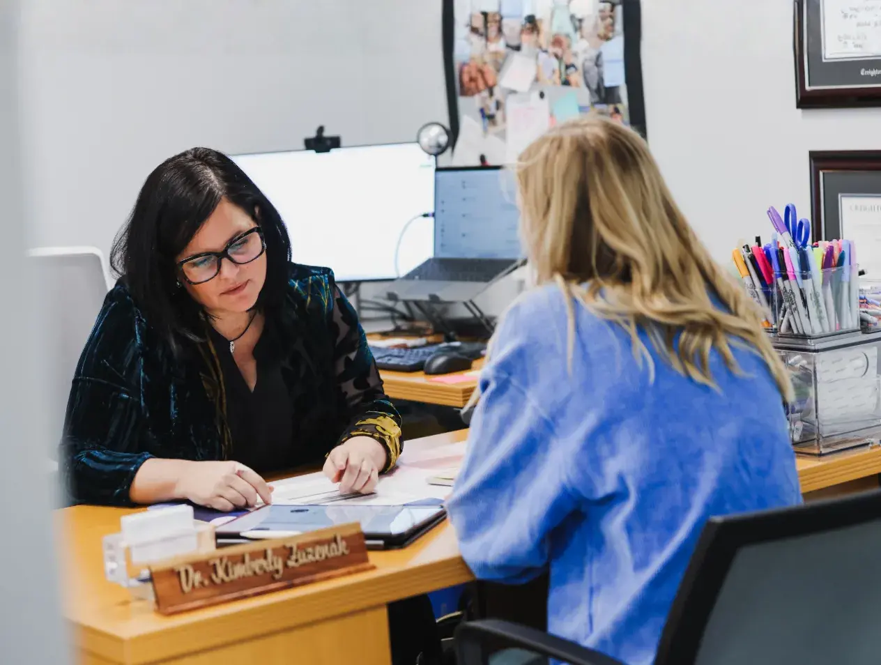 Advisor with student at desk. 