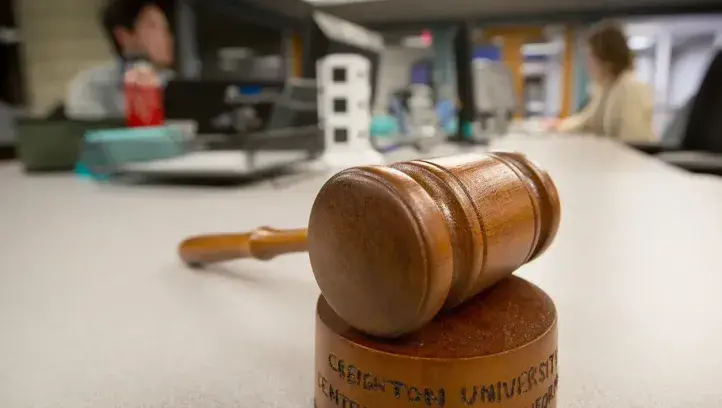 Picture of gavel on a table with people talking