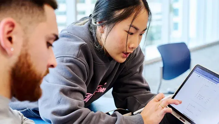 two students working on mobile tablet