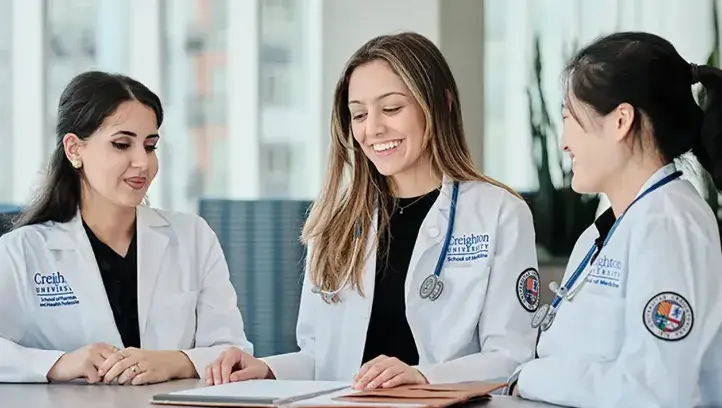 Doctors in white coats talking around a table.