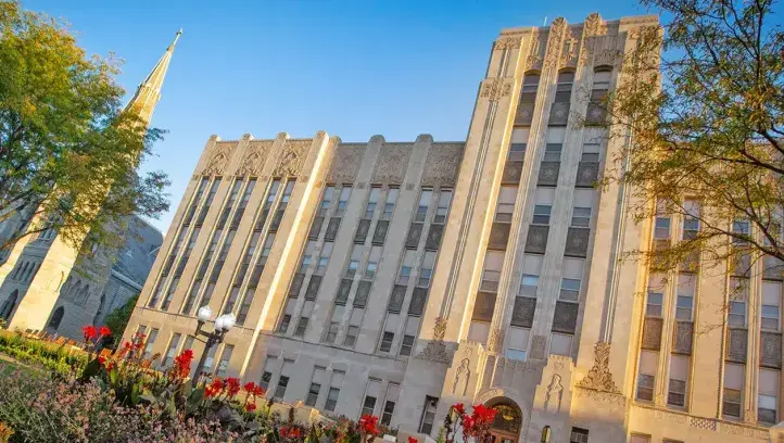 Creighton Hall with blooming flowers featured in foreground.