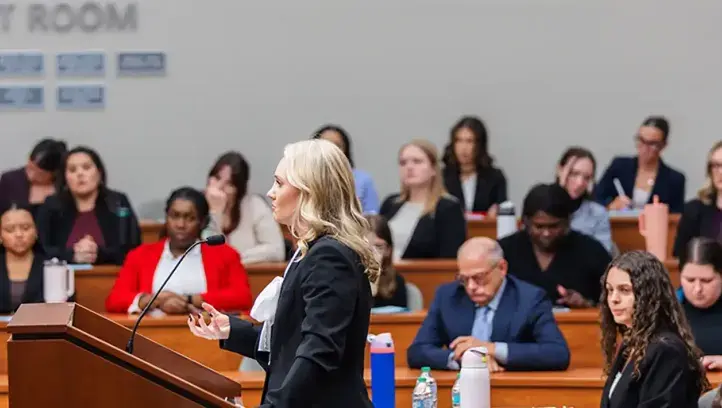 Woman speaker at the podium in student court room.