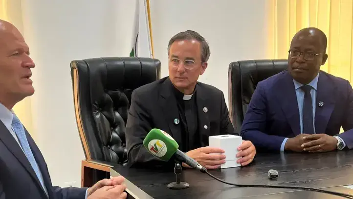 Father Hendrickson at signing agreement with colleagues.