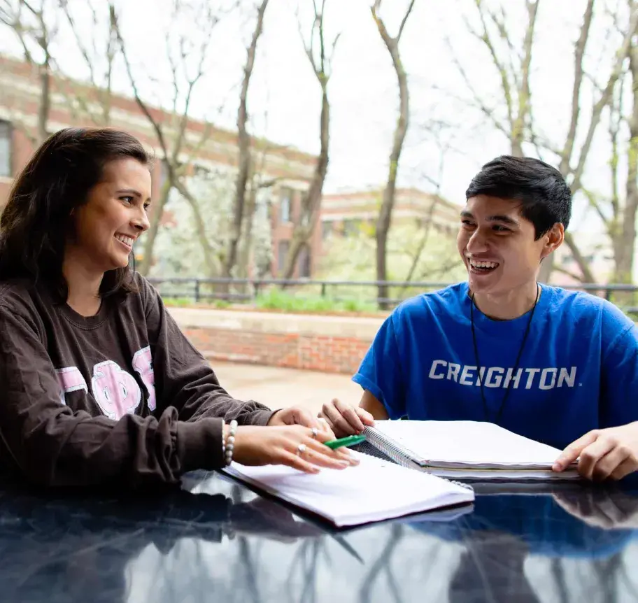 Students outdoors at table studying