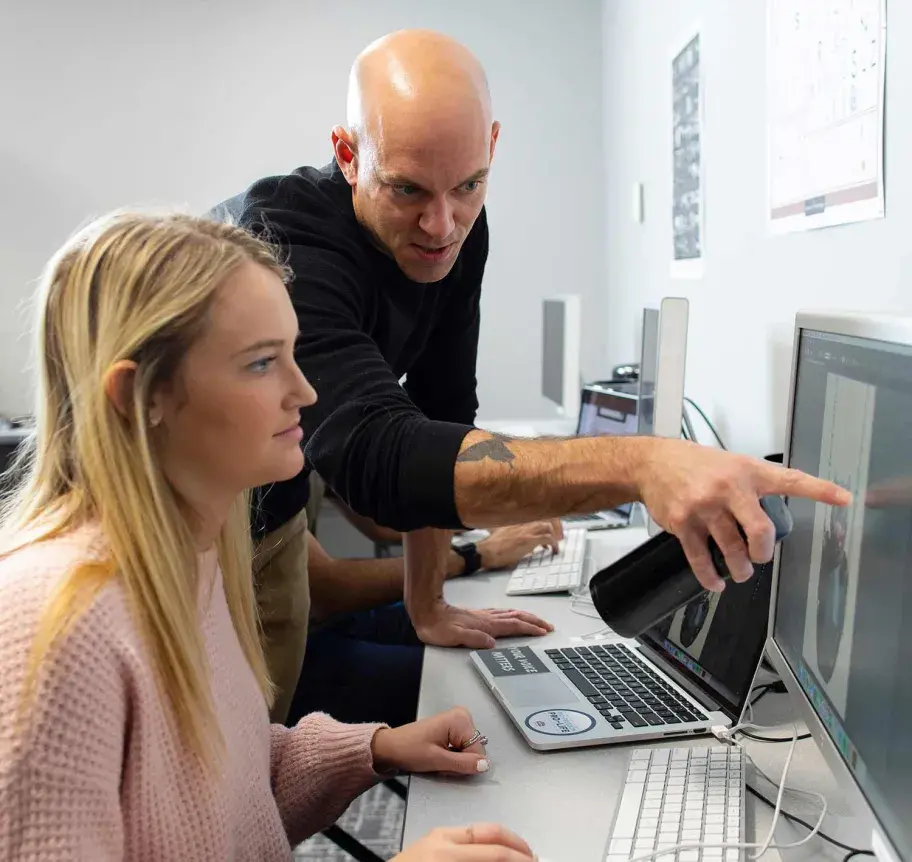 Faculty interacting with student at computer