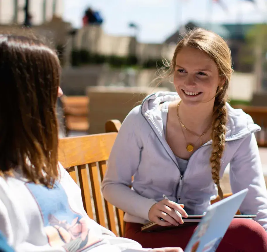 Creighton students outdoors sitting on bench