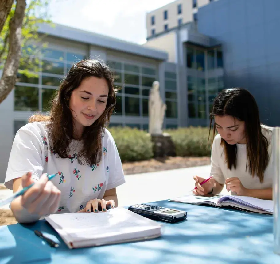 Students sitting outside at table studying