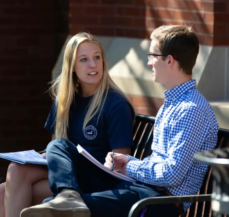 Students sitting outside on bench