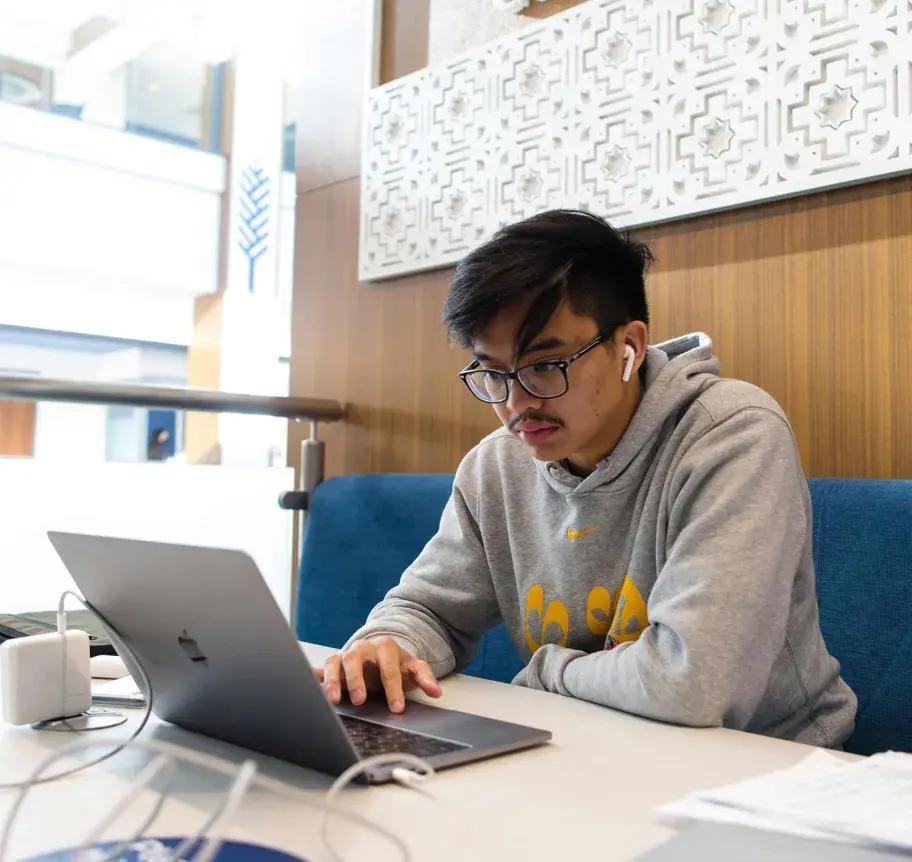 Creighton student working at laptop