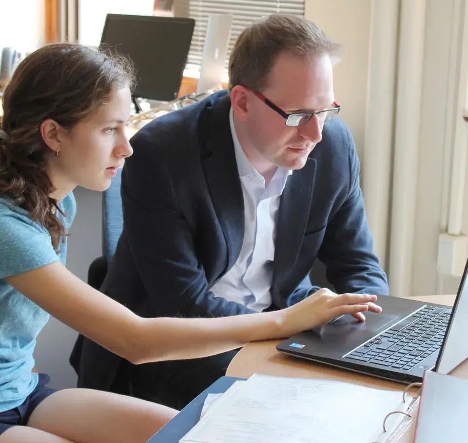 Faculty working with student at laptop