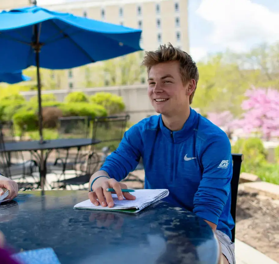 Student sitting outdoors on Creighton campus