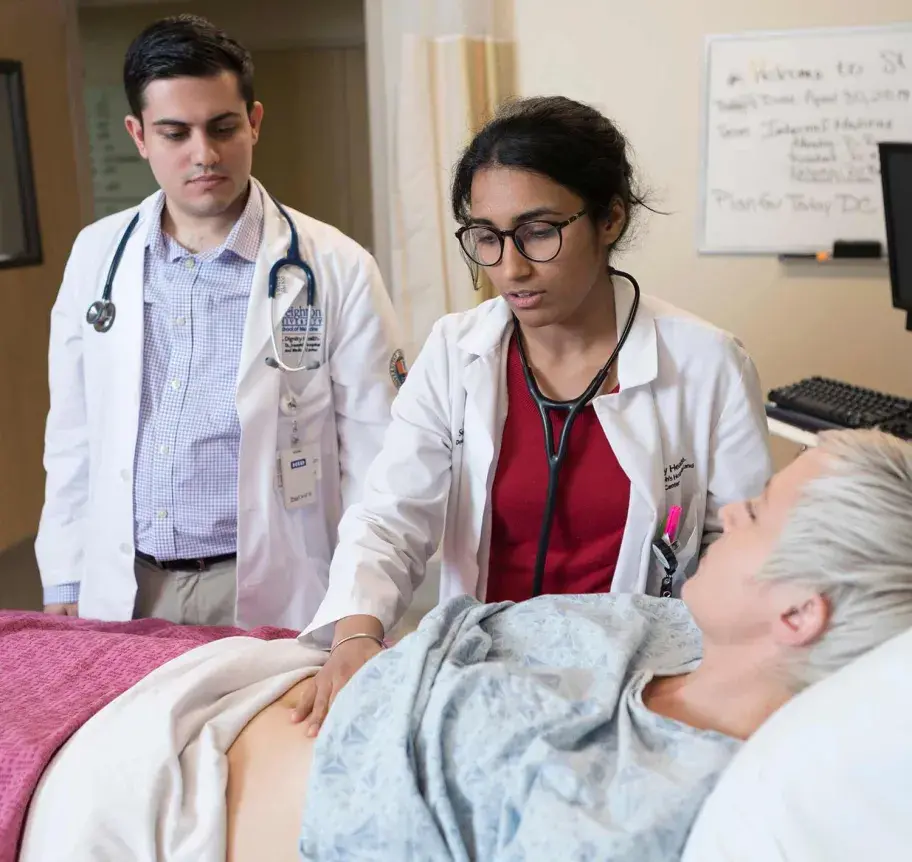 Physician assistant student and faculty working with patient