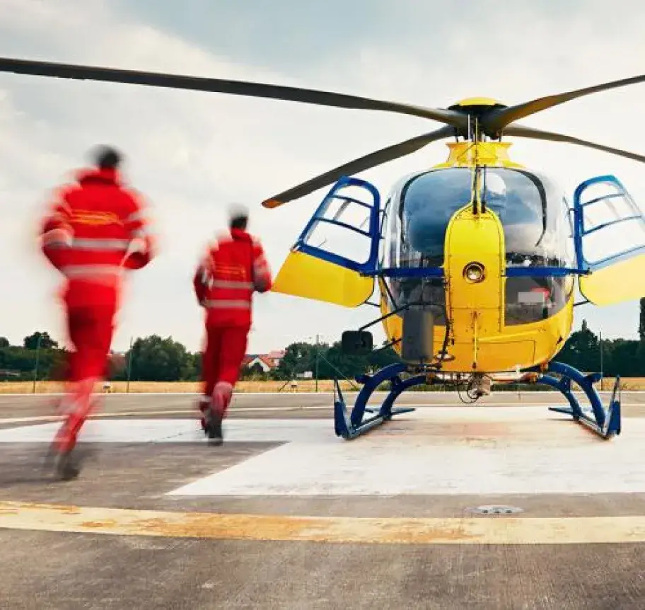 EMS professionals running toward a medical helicopter