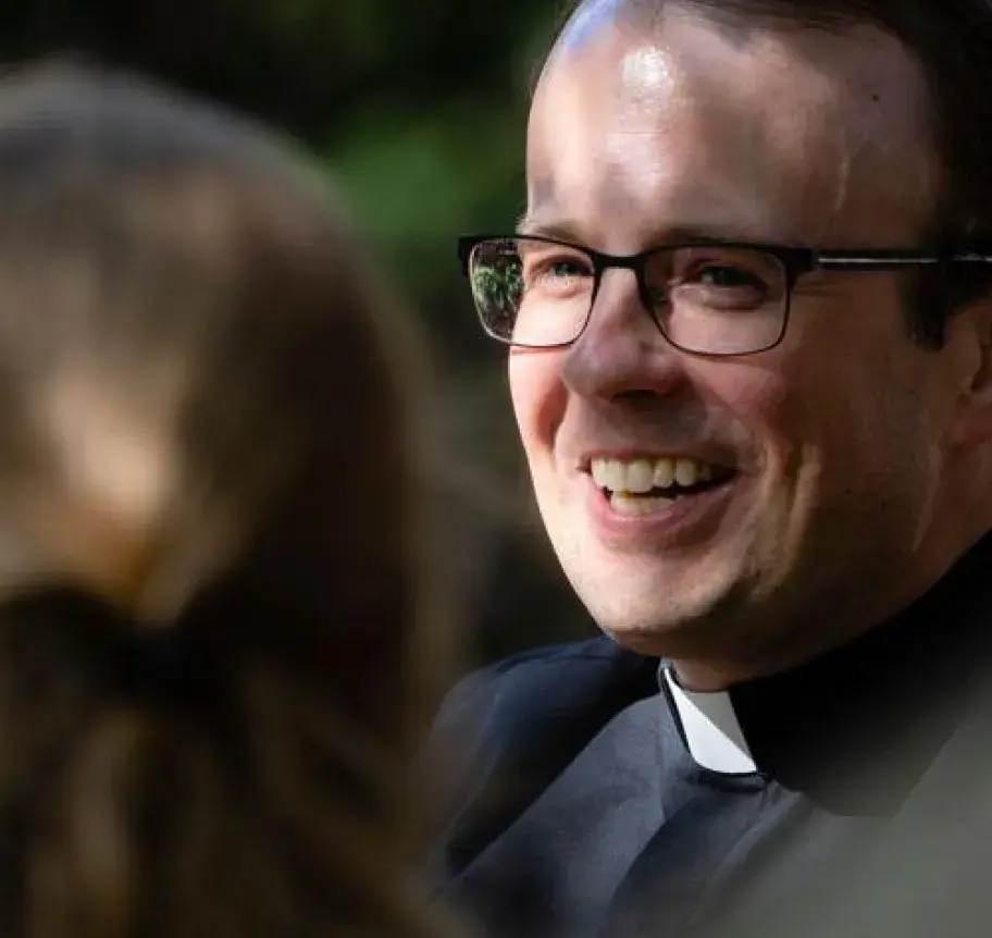 A priest talking to another person