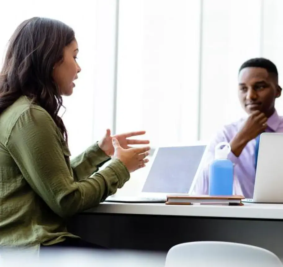 Business professionals sitting at a table with laptops
