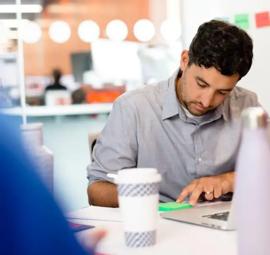 A man writing on a sticky note