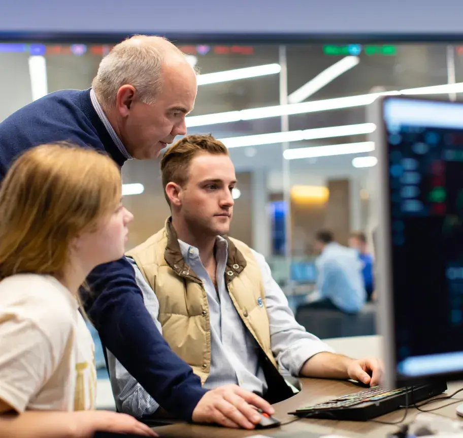 Business faculty working with students at computers