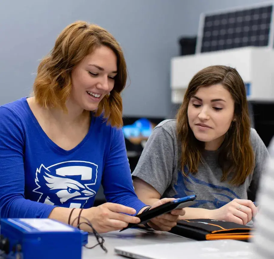 Two computer science students working together on equipment