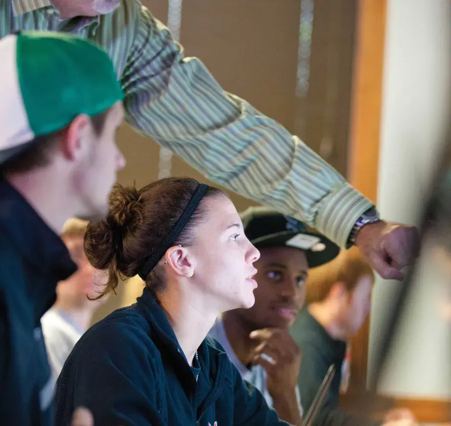 Students at computer being instructed by faculty