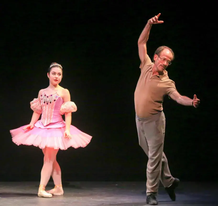 Dance faculty instructing dance student on stage