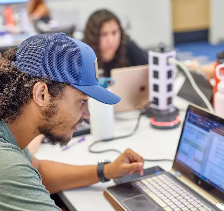 Student working on laptop in classroom