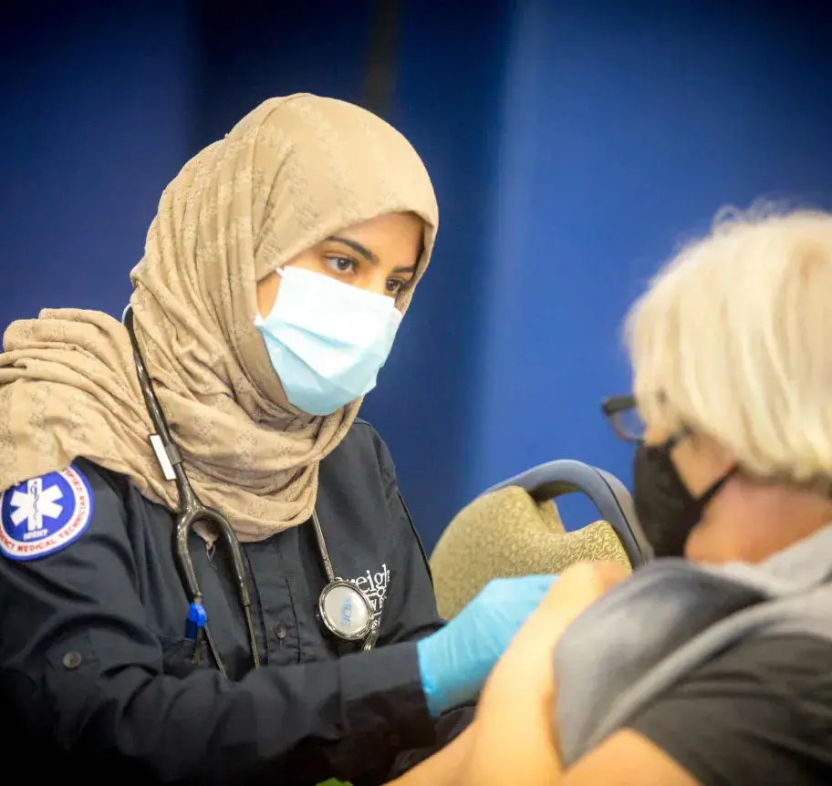 EMS student administering vaccine