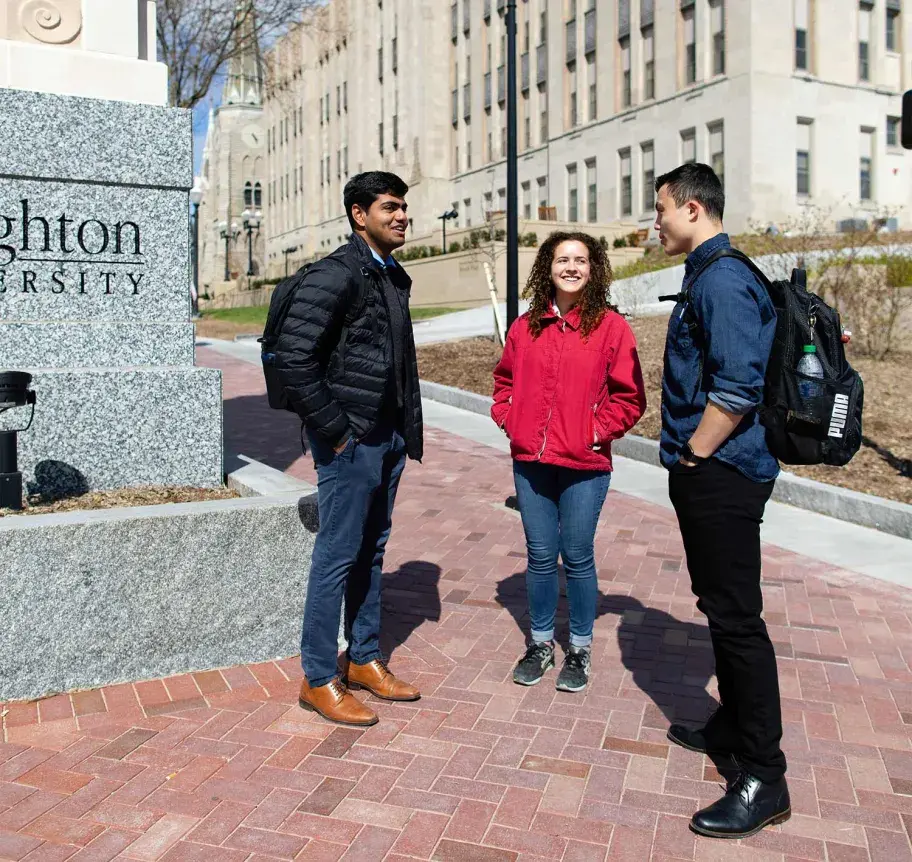 Students gathered outdoors by pillars on Creighton campus
