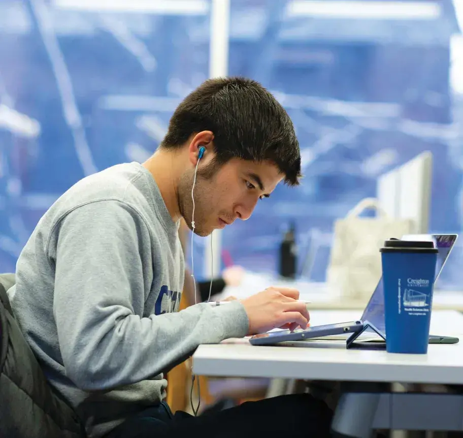 Student studying on laptop on campus