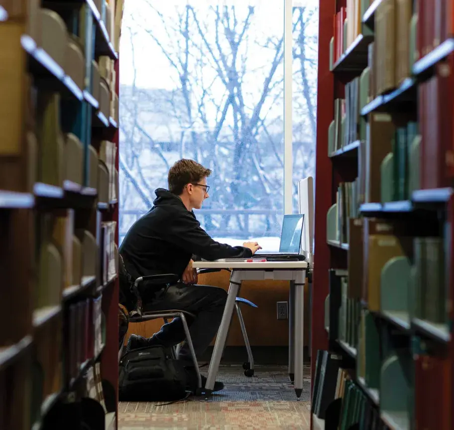 Student working on laptop in library