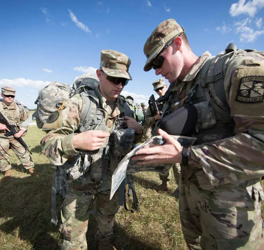 Military science students and faculty planning in the field