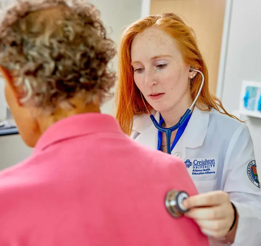 Physician assistant student listening to patient heart with stethascope
