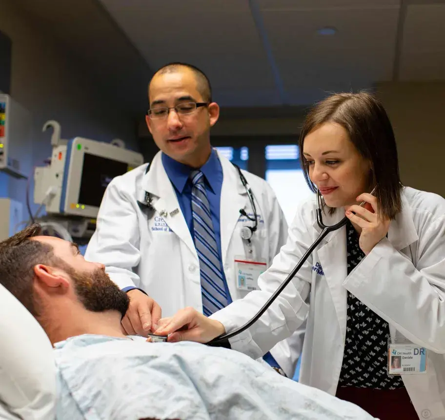 Faculty working with physician assistant student assessing patient
