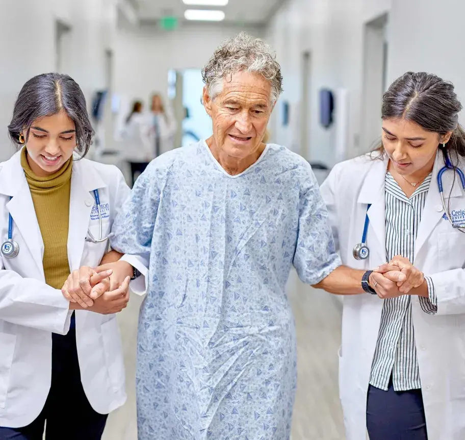 Physician assistant students helping patient walk