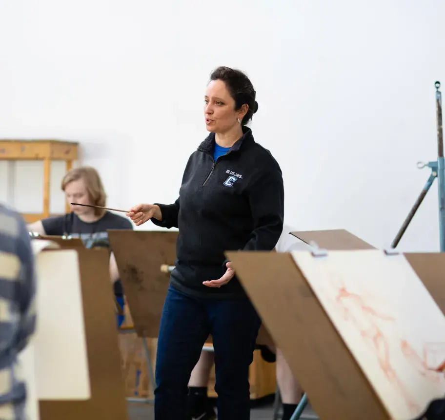 Faculty instructing students in art studio