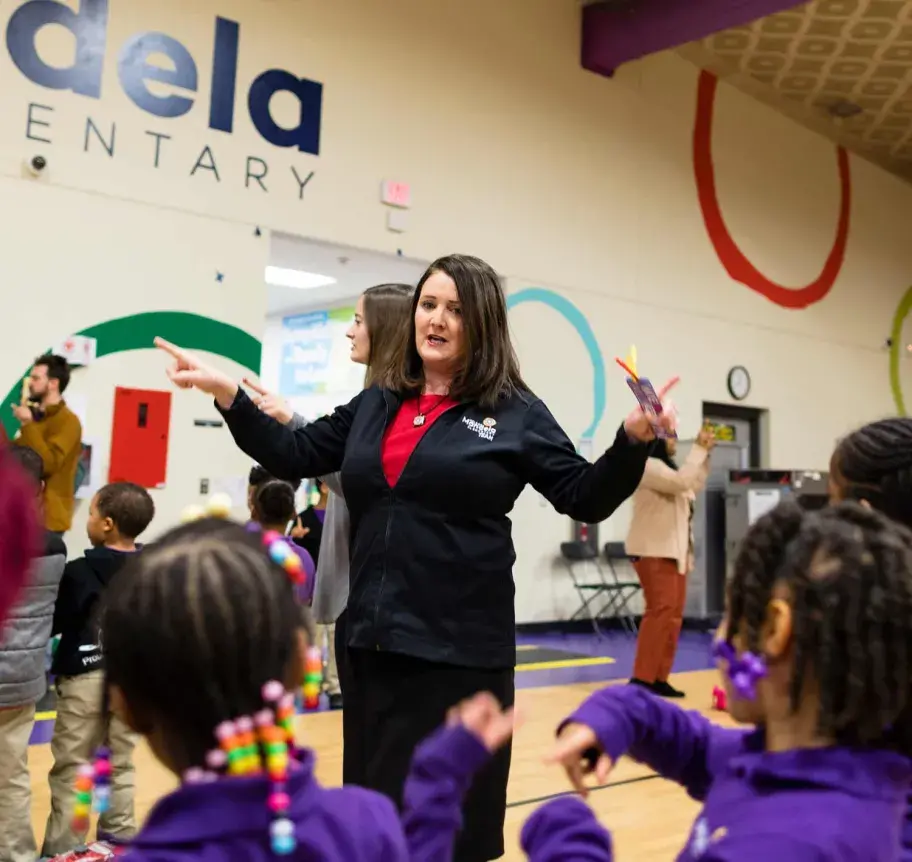 Elementary teacher speaking to students in gym