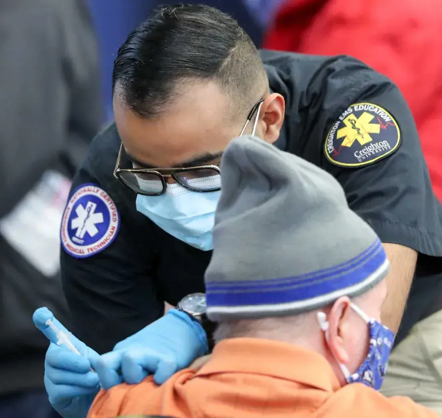 EMS student administering covid-19 vaccine