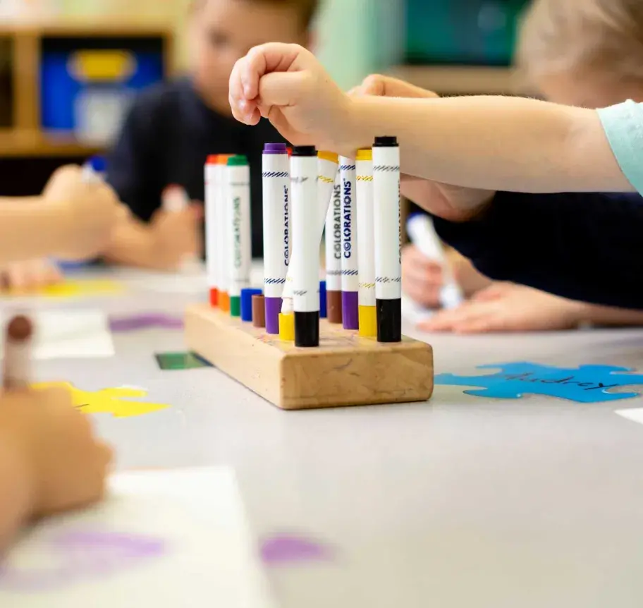 Early childhood setting with markers and tiny hands