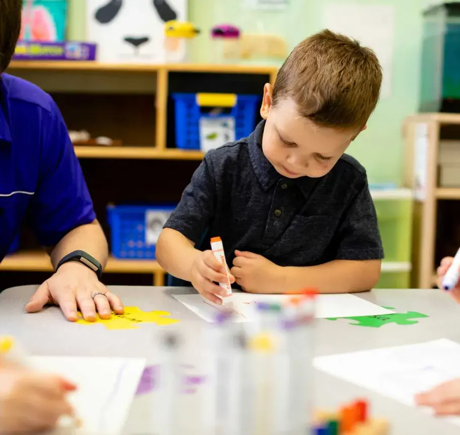 Young child in classroom using markers