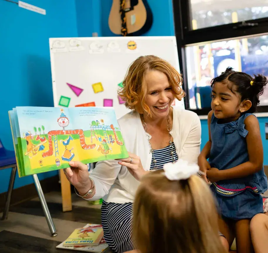 Teach and young child in the classroom reading