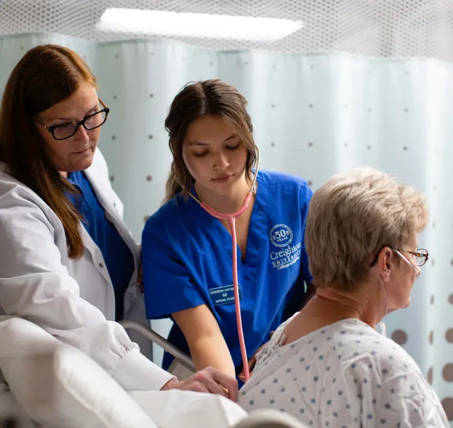 Nursing faculty and student working together to assess patient
