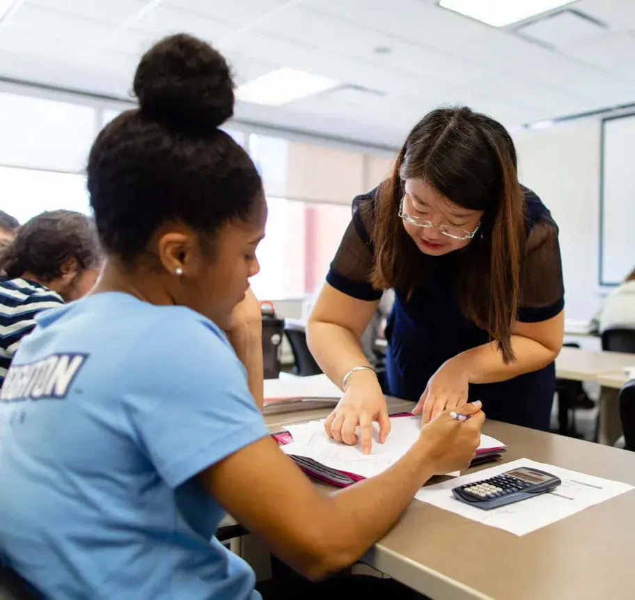Finance faculty working with student in classroom