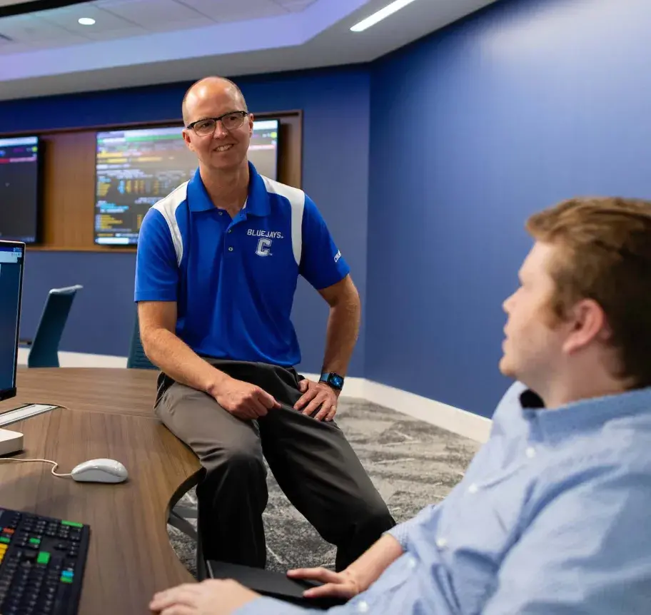 Finance faculty working with student in classroom