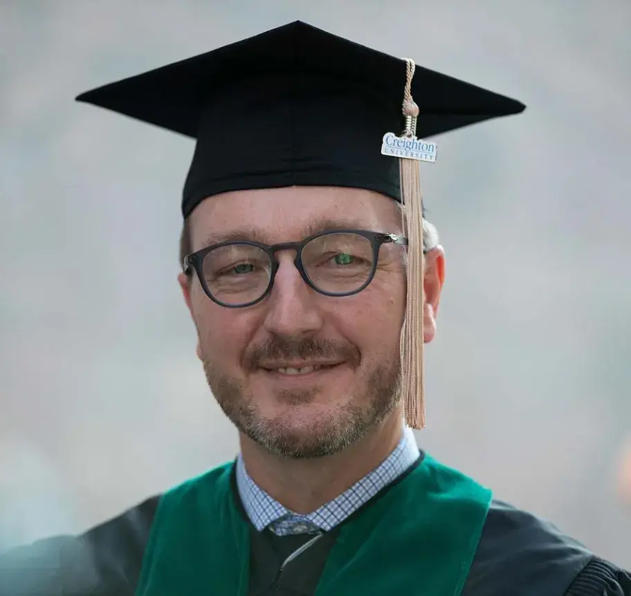 EMBA Hooding Ceremony: Graduate smiling