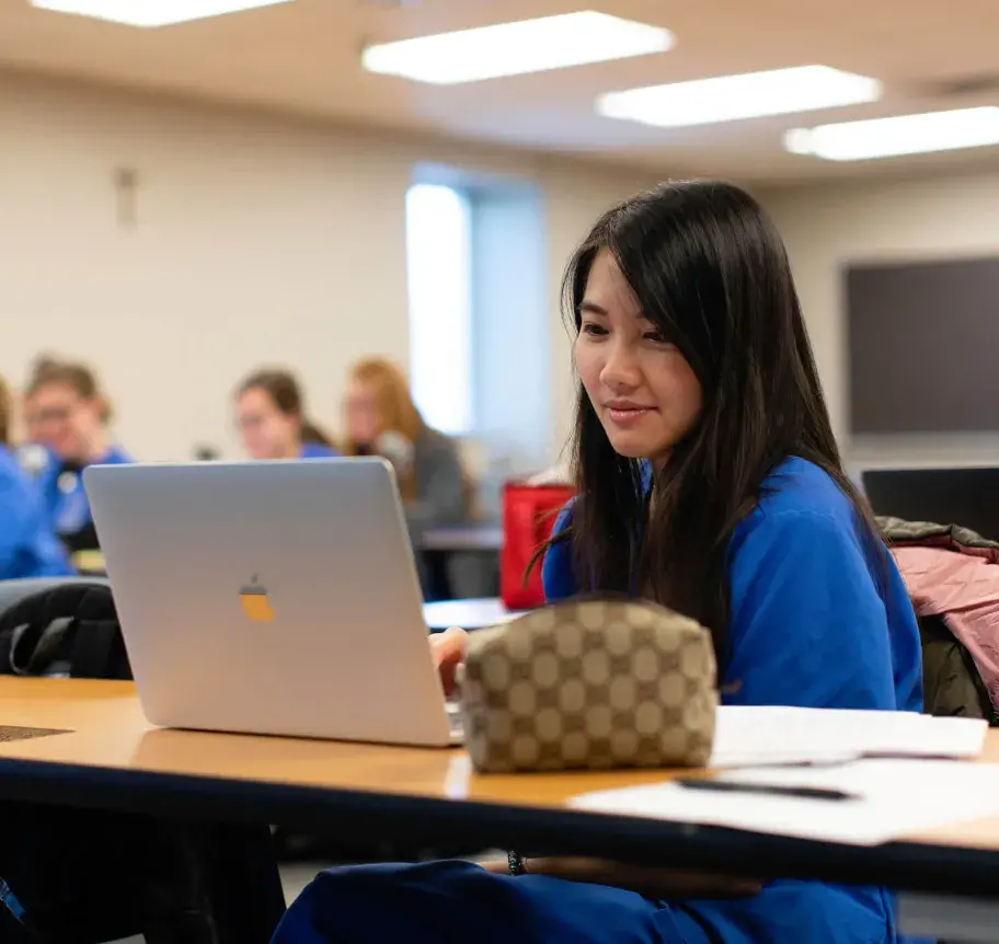 Student using laptop in classroom